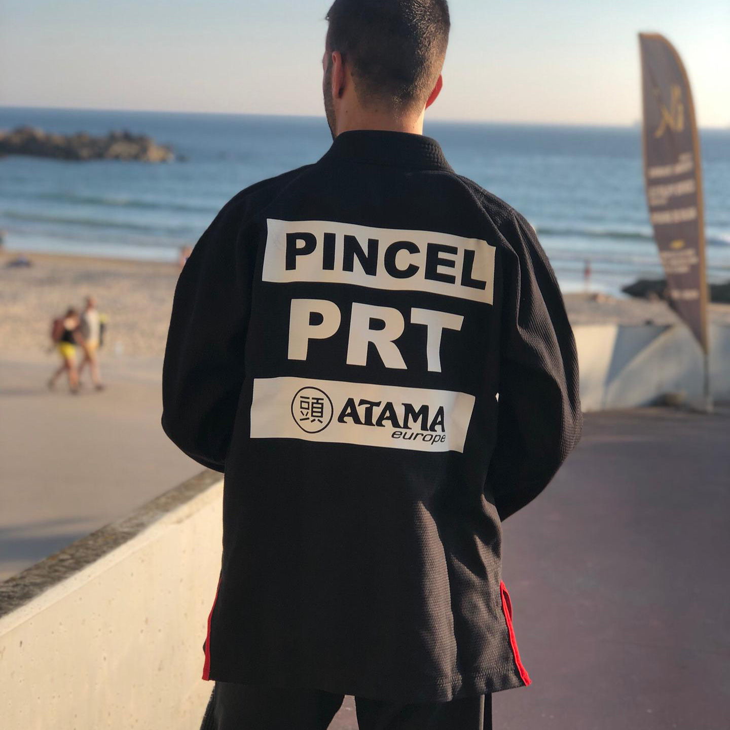 Custom white patches on a black Atama BJJ Gi at the beach